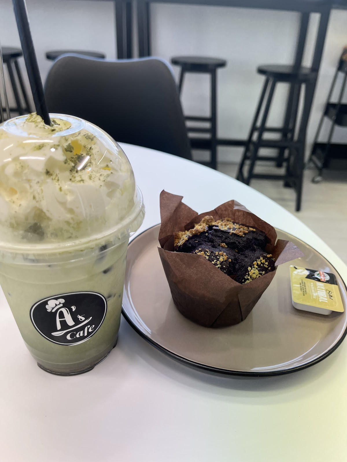 Iced matcha in a branded cup with a chocolate muffin