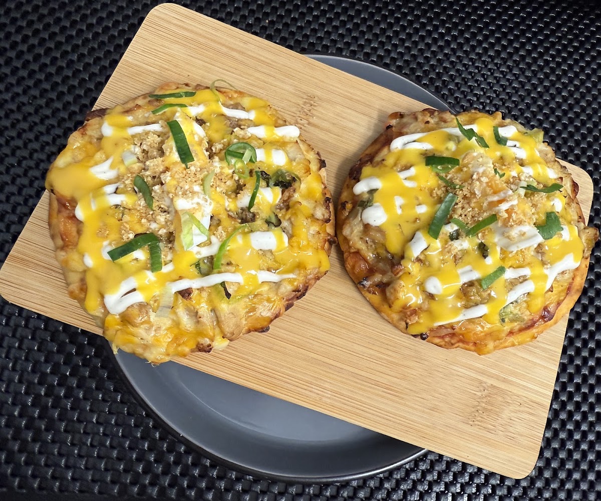 Chicken sisig mini pizzas on a wooden board