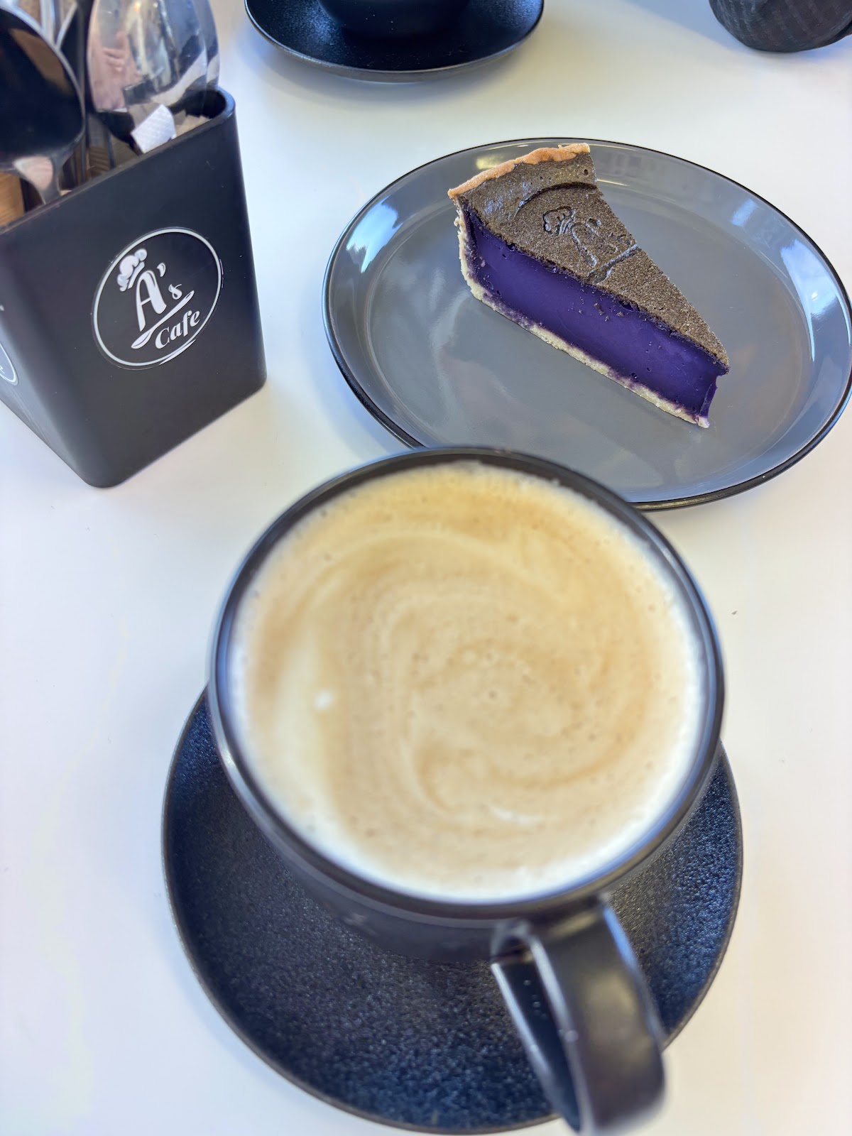 Ube custard tart slice with a flat white